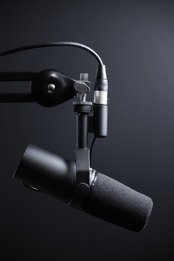 Un microphone de studio professionnel fixé sur un bras mécanique articulé prêt pour l'enregistrement d'un balado